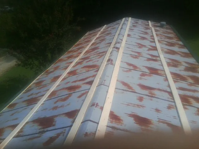 Rusted metal roof panels with new wood purlins before replacement — Storm Damage Roof Repair in Gunnison by Roofing Brothers